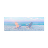 a couple of chairs sitting on top of a sandy beach